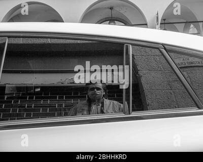 Cremona, Lombardei, Italien - 26. April 2020 - Fotograf reflektiert ein geparktes Auto, Stadtleben während Coronavirus Stockfoto