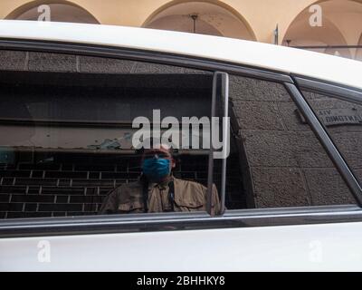 Cremona, Lombardei, Italien - 26. April 2020 - Fotograf reflektiert ein geparktes Auto, Stadtleben während Coronavirus Stockfoto