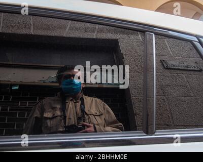 Cremona, Lombardei, Italien - 26. April 2020 - Fotograf reflektiert ein geparktes Auto, Stadtleben während Coronavirus Stockfoto