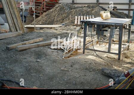 Buzz Säge auf einer Baustelle. Das eingerückte Blatt unter einer Kunststoff-Schutzabdeckung. Es ist Holz in Bretter geschnitten und säge Staub herum. Stockfoto