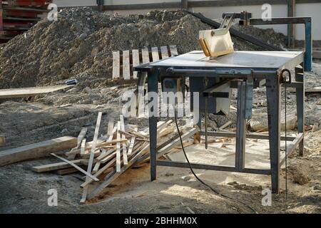 Detail einer Bussäge auf einer Baustelle. Das eingerückte Blatt unter einer Kunststoff-Schutzabdeckung. Es ist Holz in Bretter geschnitten und säge Staub herum. Stockfoto