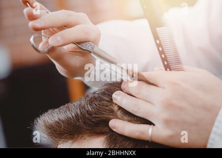 Nahaufnahme des männlichen Friseursalons, Haarschnitt mit Schere, braune Tönung, barber Shop Konzept Stockfoto