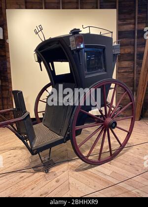 Dieses Hanson-Taxi im Shelburne Museum stammt aus dem Jahr 1895. Es ist aus Polychromholz, Eisen, Glas, Lackleder und Gummi. Benannt wurde das Fahrzeug nach dem englischen Architekten Joseph A. Hansom, der 1834 das Originaldesign patentiert hatte. Das Hansom-Taxi war das erste „Taxi“ oder eine Kutsche, die in englischen Städten gemietet wurde und wurde als „Gondel von London“ bekannt. Später im 19. Jahrhundert wurde es in den Vereinigten Staaten populär. Dieses wurde von Hinks & Johnson in Bridgeport, Connecticut, gebaut. Stockfoto