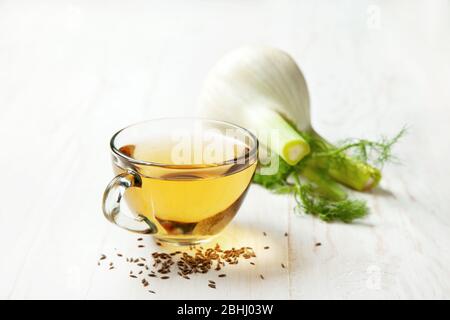 Fencheltee in einer Glasschale, frischer Fenchel auf weißem Holzhintergrund Stockfoto