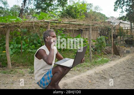 indischer Landbauer mit Laptop und Handy Stockfoto