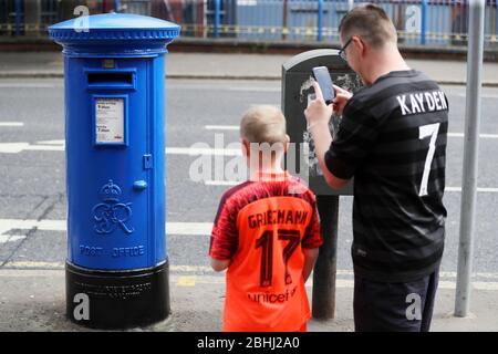 Paul Moore, ein Reinigungskraft im Royal Victoria Hospital, fotografiert mit seinem Sohn Kayden Parker (10) einen Briefkasten vor dem Hospital an der Falls Road, Belfast, der zur Unterstützung der NHS-Gesundheitsfachkräfte blau gestrichen wurde. Stockfoto