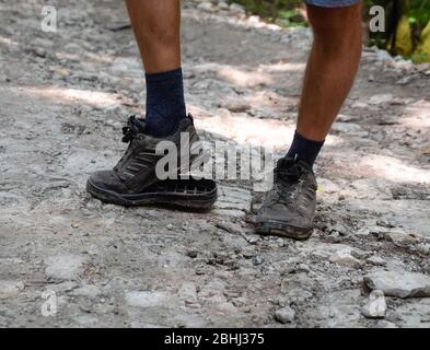 Die abgelöste Sohle auf den Turnschuhen des Touristen. Sie brachen ihre Stiefel im Wald. Stockfoto