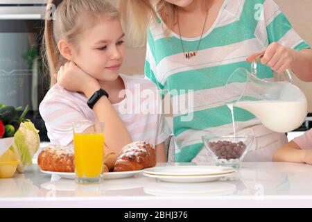 Mutter serviert Frühstück ihrer Tochter an einem Tisch in der Küche, glücklich ledig Mutter Konzept Stockfoto