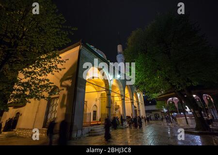 SARAJEVO, BOSNIEN-HERZEGOWINA - 15. APRIL 2017: Menschen, die vor der Moschee Gazi Husrev Begova in Sarajevo beten. Die Moschee ist das wichtigste Wahrzeichen der Th Stockfoto