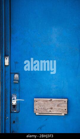 Blaue Tür mit vernagelten Briefkasten Stockfoto