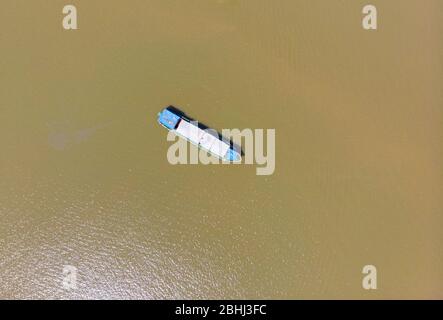 Cargo Boot schwimmend auf dem Mekong Delta region, Can Tho, South Vietnam. Direkt oberhalb von Oben nach Unten nautische Schiff auf Braun schlammigen Wasser. Stockfoto