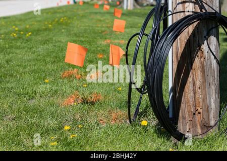 Lichtwellenleiter, orangefarbene Markierungsfahnen und Strommast. Konzept der Grabsicherheit, Dienstprogramm lokalisieren Service und High-Speed-Internet, Breitband-Zugang Stockfoto