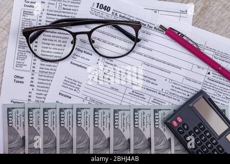 2020 Steuererklärung 1040 mit Rechner und Fokus durch Brille. Das Konzept der Einreichung einer Steuererklärung, Zahlung, Rückkehr vor April 2021 Stockfoto