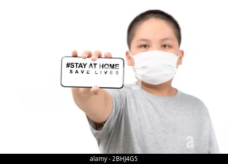 Kinderkleidung medizinische Maske zeigt ein Mobiltelefon mit zu Hause bleiben Leben retten Worte isoliert auf weißem Hintergrund, Coronavirus, COVID-19, selbst-Quarantäne, Stockfoto