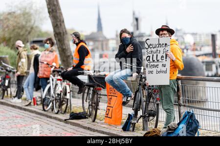 Hamburg, Deutschland. April 2020. Ein Demonstrator hält ein Schild mit der Aufschrift "epidemischer Schutz für alle! Lass keine ne hinter'. Aktivisten der Hilfsorganisation Seebrücke demonstrieren in einer Kette von 20 Standorten von der Fischauktionsallee bis zu den Deichtorhallen mit Schildern und Transparenten für eine Auflösung der Flüchtlingslager in Griechenland. Quelle: Markus Scholz/dpa/Alamy Live News Stockfoto