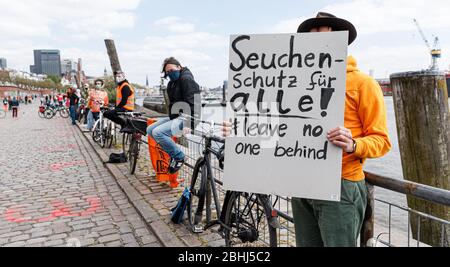 Hamburg, Deutschland. April 2020. Ein Demonstrator hält ein Schild mit der Aufschrift "epidemischer Schutz für alle! Lass keine ne hinter'. Aktivisten der Hilfsorganisation Seebrücke demonstrieren in einer Kette von 20 Standorten von der Fischauktionsallee bis zu den Deichtorhallen mit Schildern und Transparenten für eine Auflösung der Flüchtlingslager in Griechenland. Quelle: Markus Scholz/dpa/Alamy Live News Stockfoto