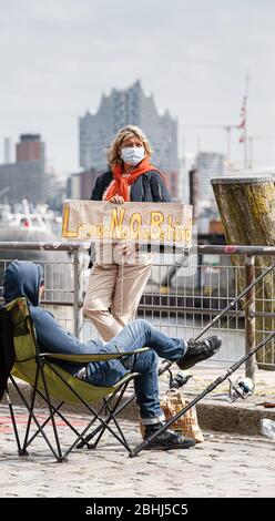 Hamburg, Deutschland. April 2020. Ein Demonstrator hält ein Schild mit der Aufschrift "Leave no one behind". Aktivisten der Hilfsorganisation Seebrücke demonstrieren in einer Kette von 20 Standorten von der Fischauktionsallee bis zu den Deichtorhallen mit Schildern und Transparenten für eine Auflösung der Flüchtlingslager in Griechenland. Quelle: Markus Scholz/dpa/Alamy Live News Stockfoto