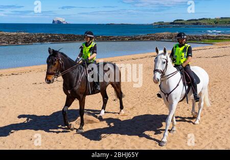 North Berwick, Schottland, Großbritannien. 26. April 2020. Berittene Polizisten patrouillieren heute Nachmittag an den Stränden von North Berwick in East Lothian. Die Pferde Inverness (dunkel) und Edinburgh reisten von ihren Ställen in Stewarton in Ayrshire für den heutigen Spaziergang. Die Strände waren jedoch sehr ruhig und die Pferde mussten sich mit den wenigen Leuten draußen fotografieren lassen. Iain Masterton/Alamy Live News Stockfoto