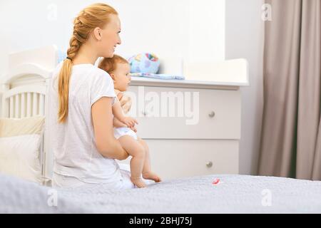 Mutter und Baby liegen auf dem Bett. Muttertag. Stockfoto