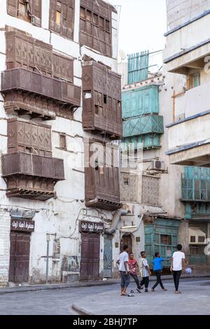 Jeddah / Saudi Arabien - 16. Januar 2020: Menschen neben bunten historischen Gebäuden auf den Straßen von Al-Balad Stockfoto