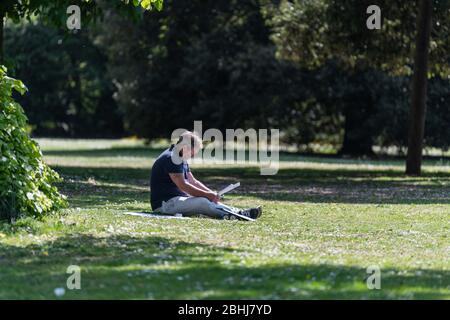 Cheltenham, Großbritannien. April 2020. . Während der landesweiten Sperrung des Coronavirus genießt das Publikum eine ruhige Lektüre im Pittville Park. Quelle: Adriano Ribeiro/Alamy Live News. Stockfoto