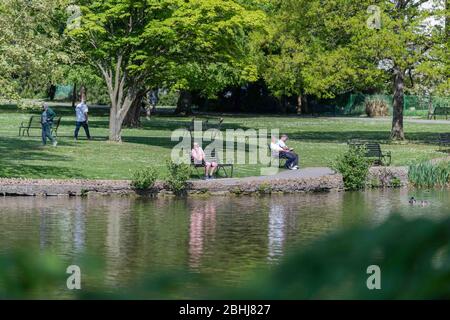 Cheltenham, Großbritannien. April 2020. . Die Öffentlichkeit genießt während der landesweiten Sperrung des Coronavirus ein wenig Sonnenschein auf einigen der Parkbänke im Pittville Park. Quelle: Adriano Ribeiro/Alamy Live News. Stockfoto