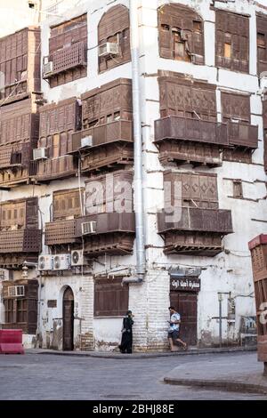 Jeddah / Saudi Arabien - 16. Januar 2020: Menschen neben bunten historischen Gebäuden auf den Straßen von Al-Balad Stockfoto