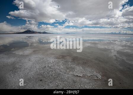 Bonneville Salt Flats nach einem Regensturm. Spiegelungen von Himmel und Wolken spiegeln sich auf dem flachen Salt playa nahe dem Bonneville Speedway. Utah, USA. Stockfoto