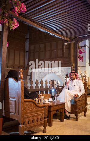 Jeddah / Saudi Arabien - 16. Januar 2020: Saudi-arabisches muslimisches Paar in traditioneller Kleidung und in einem schönen Restaurant, um Kaffee zu trinken Stockfoto