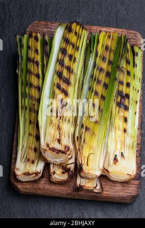 Gegrillte Babylauch auf schwarzem Steingrund Stockfoto