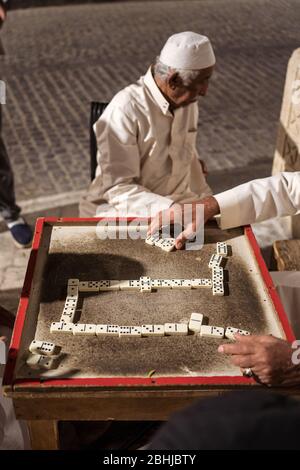 Dschidda / Saudi-Arabien - 16. Januar 2020: Alte muslimische Männer spielen nachts Dominosteine in den Straßen des historischen Al-Balad Stockfoto