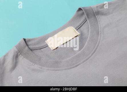 Leere Tag von grauen T-Shirt für Ihr Design isoliert auf blauem Hintergrund. Stockfoto