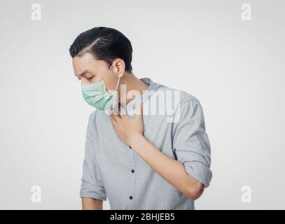 Junge asiatische Geschäftsmann in hygienischen Maske leiden Halsschmerzen, 2019-nCoV oder Coronavirus. Atemwegserkrankungen wie PM 2.5 Kampf und Grippe Stockfoto