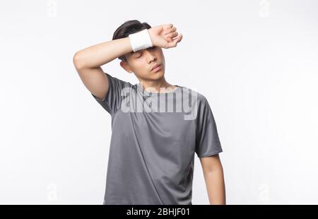 Junge asiatische Mann in Sport-Outfits müde nach der Übung isoliert auf weißem Hintergrund. Stockfoto