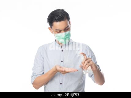 Junge asiatische Geschäftsmann trägt hygienische Maske und mit Hand Sinitizer oder Alkohol Gel, verhindern Infektion, 2019-nCoV oder Coronavirus. Atemschutzmaske in der Luft Stockfoto