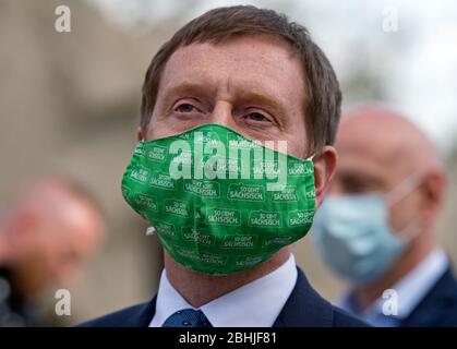 26. April 2020, Sachsen-Anhalt, Halle (Saale): Michael Kretschmer (CDU), Ministerpräsident von Sachsen, trägt nach einer Pressekonferenz im Bergzoo Halle/Saale eine Gesichtsmaske mit der Aufschrift "so geht Sächsisch". Zuvor hatten die beiden Regierungschefs von Sachsen und Sachsen-Anhalt über die weitere Vorgehensweise im Umgang mit der Corona-Pandemie diskutiert. Die beiden Staatschefs werden gemeinsam abwägen, welche weiteren Lockerungsmöglichkeiten und Öffnungsmöglichkeiten denkbar sind und wie das Risiko angesichts der aktuellen Infektionssituation beurteilt werden kann. Foto: Hendrik Sc Stockfoto