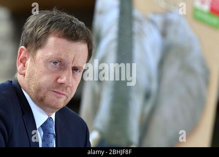 26. April 2020, Sachsen-Anhalt, Halle (Saale): Der sächsische Ministerpräsident Michael Kretschmer (CDU) sitzt bei einer Pressekonferenz im Bergzoo Halle/Saale vor einem Plakat mit einem Elefanten. Die beiden Regierungschefs von Sachsen und Sachsen-Anhalt hatten zuvor über die weitere Vorgehensweise im Umgang mit der Corona-Pandemie diskutiert. Die beiden Regierungschefs von Sachsen und Sachsen-Anhalt hatten über die weitere Vorgehensweise im Umgang mit der Corona-Pandemie diskutiert und gesagt, sie sollten gemeinsam abwägen, welche weiteren Entspannungs- und Öffnungsmöglichkeiten denkbar seien und welche Stockfoto