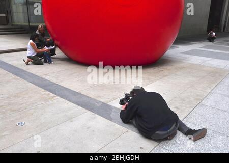 Toronto, Ontario, Kanada - 06/12/2009: Eine riesige rote Kugel wird als öffentliche Kunstausstellung zwischen Gebäuden in der Innenstadt von Toronto installiert. Fotograf auch Stockfoto