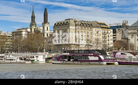 BUDAPEST, UNGARN - MÄRZ 2019: Touristische Sightseeing-Boote auf der Donau in Budapest festgemacht. Stockfoto