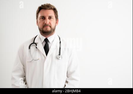 Porträt des männlichen Arztes mit Stethoskop in medizinischer Uniform posiert auf einem weißen isolierten Hintergrund Stockfoto