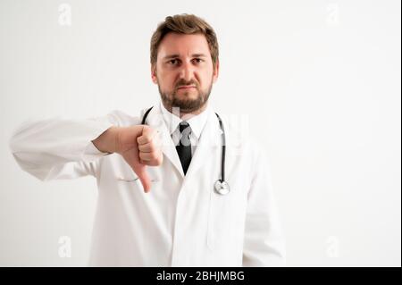 Porträt des männlichen Arztes mit Stethoskop in medizinischer Uniform, das Abneigung auf einem weißen isolierten Hintergrund zeigt Stockfoto