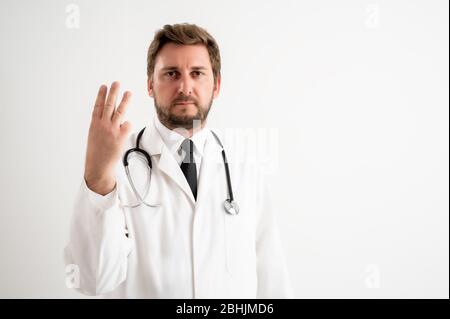 Porträt des männlichen Arztes mit Stethoskop in medizinischer Uniform, drei zählend, mit ihren Fingern auf einem weißen isolierten Hintergrund posiert Stockfoto