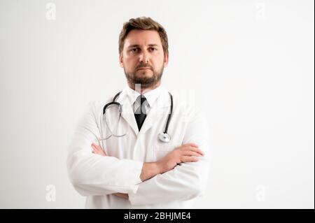 Porträt des männlichen Arztes mit Stethoskop in medizinischer Uniform suchen zuversichtlich posiert auf einem weißen isolierten Hintergrund. Stockfoto