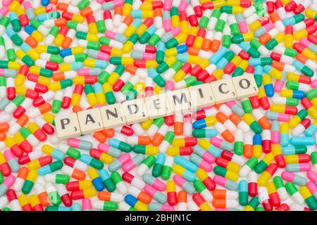 Mehrfarbige Pillen Kaplets und Buchstaben Fliesen: PANDEMICO - Spanisch & Italienisch Adjektiv für Pandemie. Coronavirus conceptual, CV19 / Covid 19 Metapher. Stockfoto