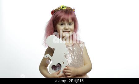 Lächelndes kleines Mädchen Prinzessin hält einen hölzernen Fotorahmen in Form einer schwangeren Frau mit Ultraschall-Foto. Weißer Hintergrund. Nettes Kind genießen glückliche Kindheit. Muttertag Konzept Stockfoto