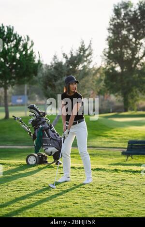 Frau, die Golf auf einem wunderschönen Golfplatz spielt Stockfoto