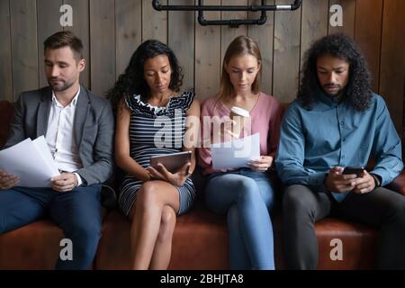 Multirassische junge Leute warten in der Linie für Vorstellungsgespräch Stockfoto