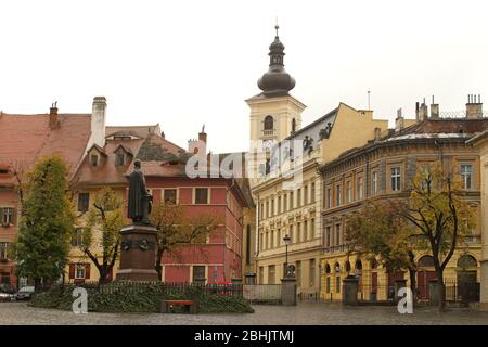 Sibiu, Rumänien. Die Statue des lutherischen Bischofs G. D. Teutsch aus dem Jahr 1899, auf dem Albert Huet Platz. Römisch-katholische Kirche der Heiligen Dreifaltigkeit (Rückseite) Stockfoto