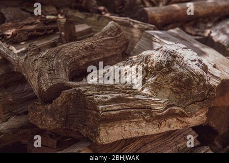 Geknüpfte Holzoberfläche von unebenen rissenen Hölzern im Sonnenlicht. Raue Holzstruktur von faseriger Struktur. Brauner Hartholz Hintergrund mit Kopierraum Stockfoto