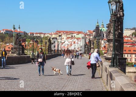 Prag, Tschechische Republik - 23. April 2020: Menschen, die medizinische Gesichtsmasken auf der Karlsbrücke in Prag, Tschechische Republik tragen. Stadtzentrum während der Coronavirus-Pandemie. COVID-19-Krise. Horizontales Foto. Stockfoto